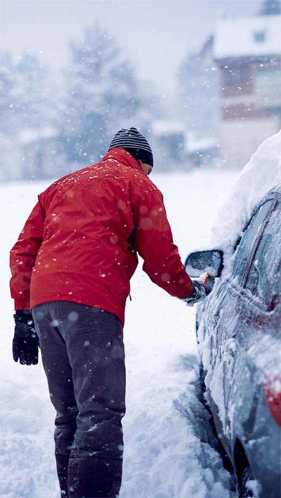 Car heating repairs during winter with driver clearing snow from vehicle before starting.