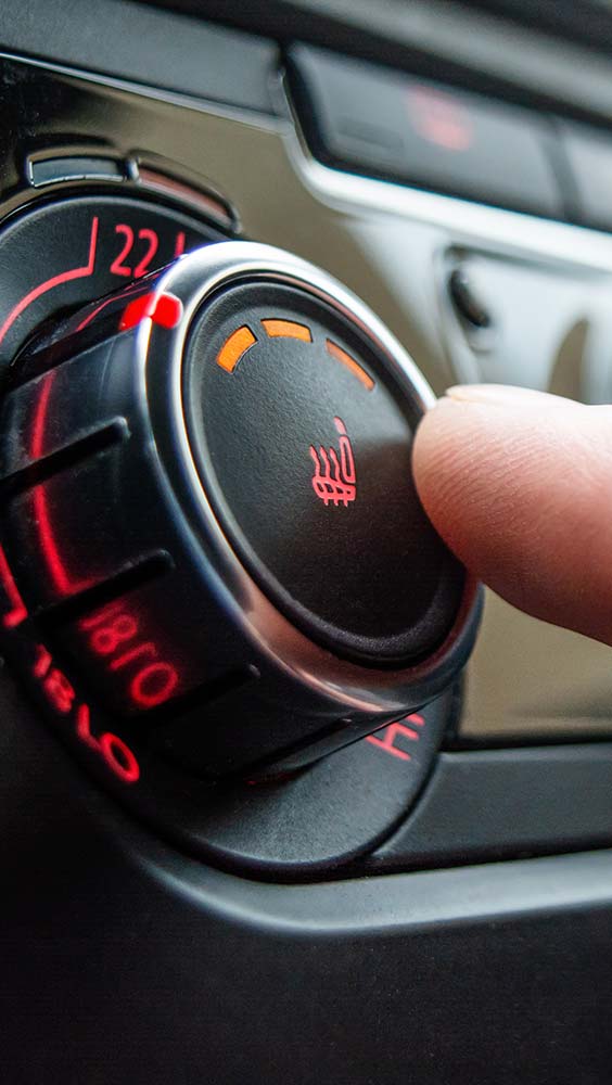 Car heating repairs showing heated seat control being adjusted inside a vehicle.
