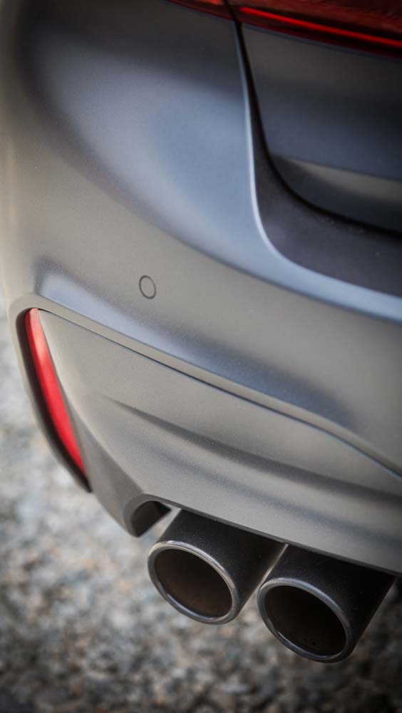 Exhaust and emissions close-up of dual exhaust tips on the rear of a car.