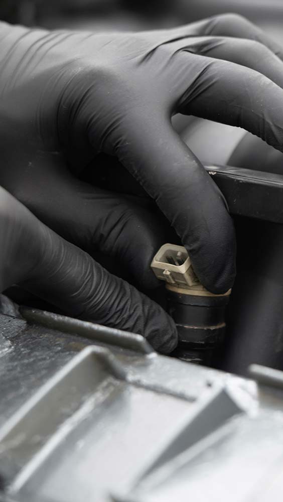Ignition and fuel system repair with a technician connecting an ignition component inside the engine.