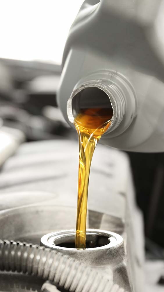 Oil change and fluid service with motor oil being poured into an engine.